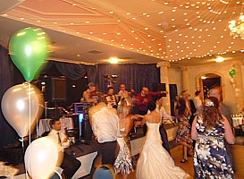 Guests dancing, with the band in the background.